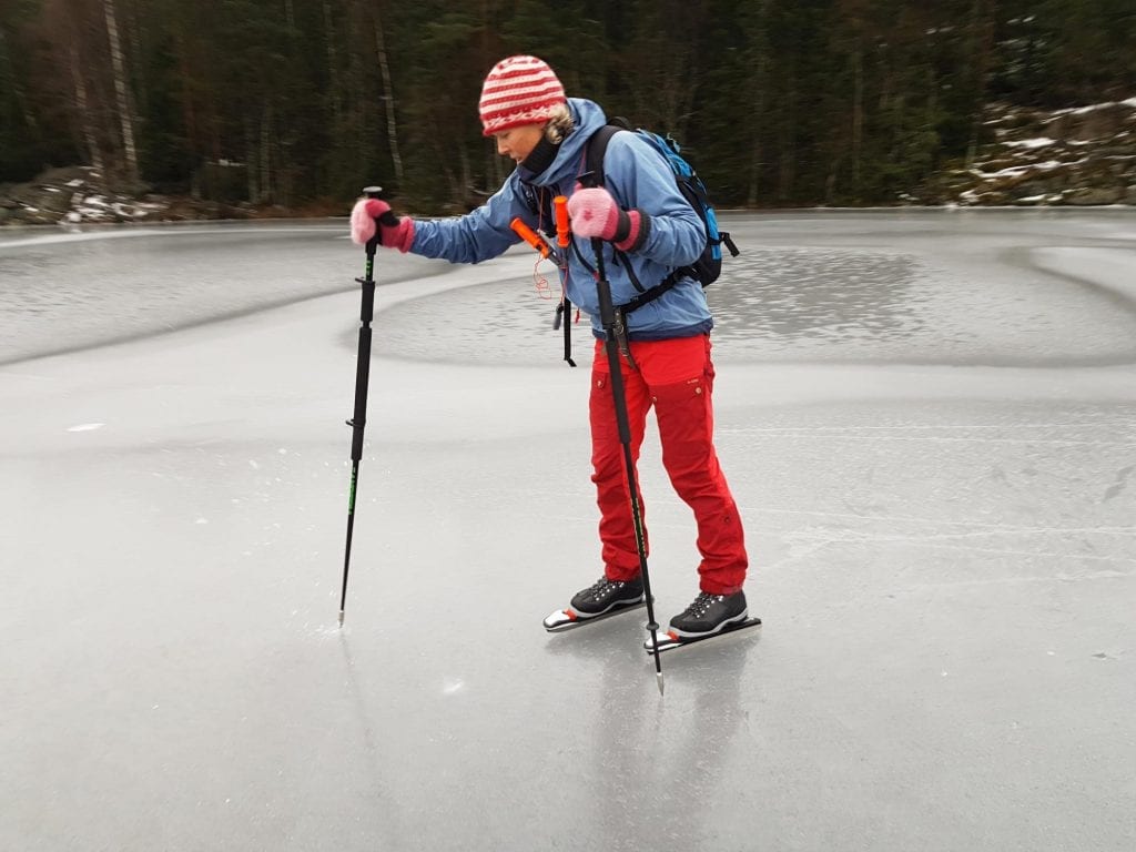 VÆR FORSIKTIG: Istykkelsen kan sjekkes med en isstav, som er tyngre og spissere enn en skistav. Personen på bildet har også ispigger rundt halsen, og kasteline og tørt skift pakket vanntett i sekken. Foto: NVE