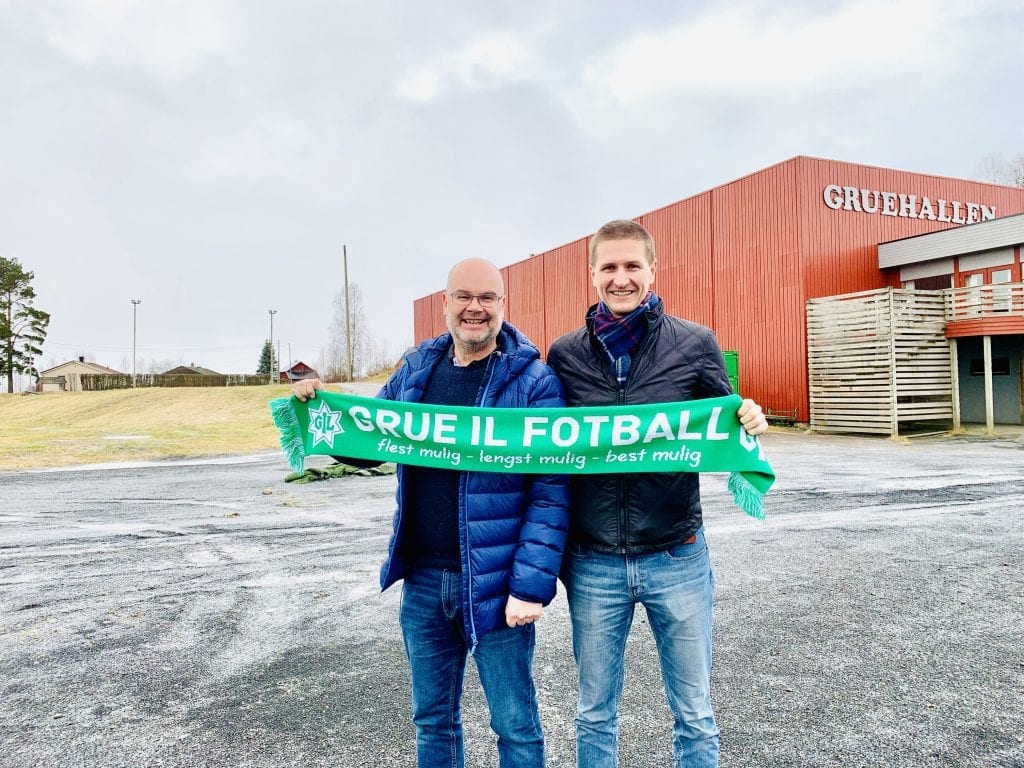 KLARE: Gjermund Holt og Rune Skasberg i prosjektgruppa. Bak dem og ved siden av Gruehallen til høyre kan det stå klar en flerbrukshall høsten 2021. Foto: Liv Rønnaug B. Lilleåsen