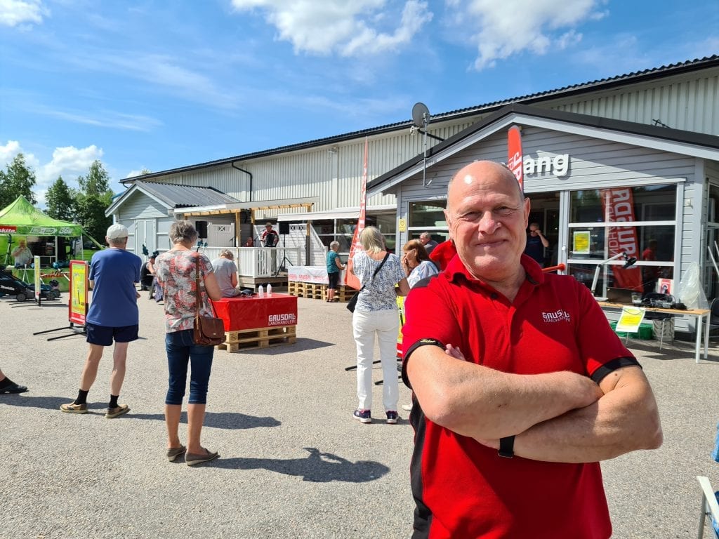 BRA PÅGANG: Byggevarehussjef Leif Julius Kalnæs forteller om bra pågang under åpningsfesten lørdag. I bakgrunn spiller Øivind Roos trekkspill sammen med Harry frå skogen.