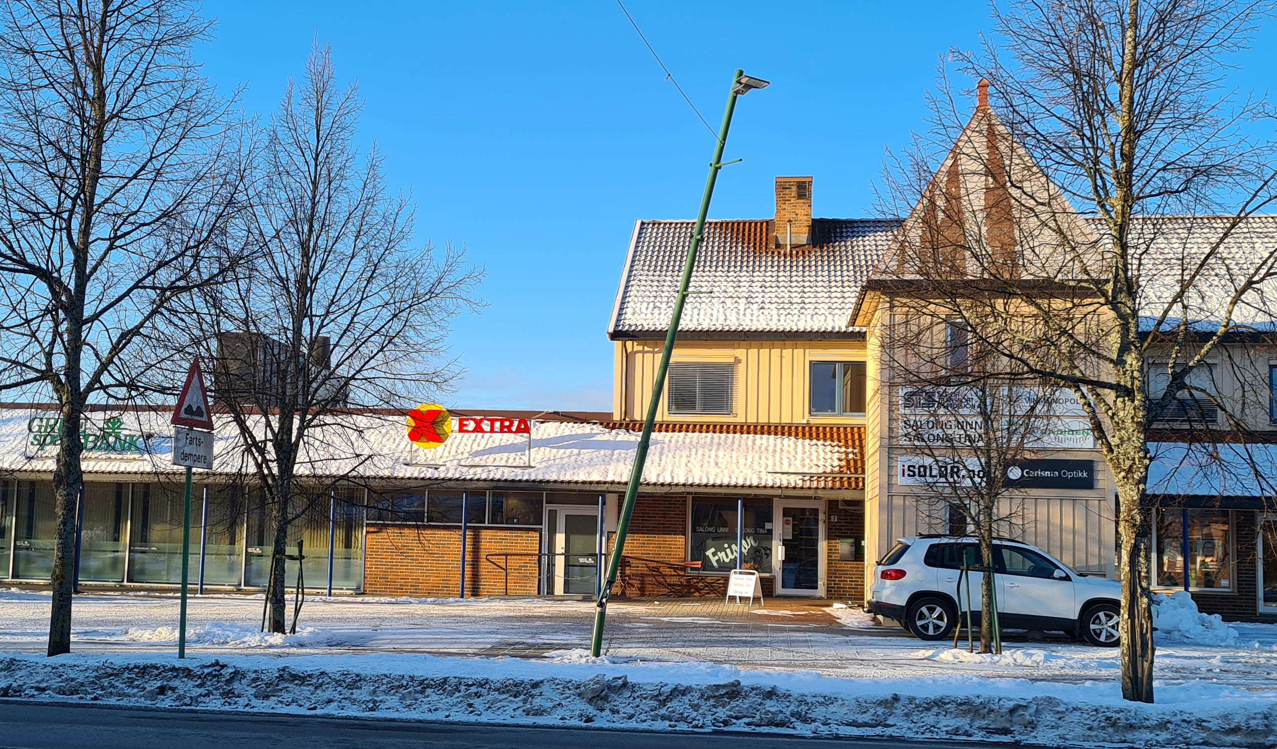 DEN SKJEVE STOLPEN PÅ FLISA: En lastebil rygget på lysstolpen utenfor Extra tirsdag kveld i forbindelse med snørydding.