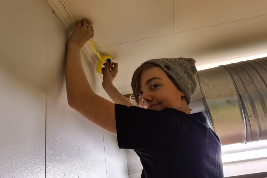 MASKERER: Fredag var det maledugnad på Bjørkheim. Jørgen Andreas Helgesen (13) var én av ungdommen som var med. Her maskerer han før malingen starter av veggen.