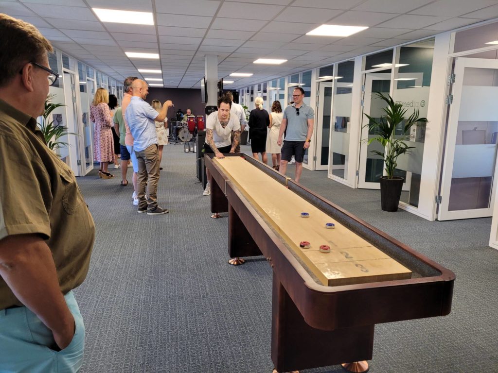IKKE BARE ALVOR: Selgerne hos HS Media trives godt, og de fleste selgerne blir i jobben i mange år. Det sosiale er viktig, som å bruke dette shuffleboardet. Petter Dammen konkurrerer gjerne både her og som selger.