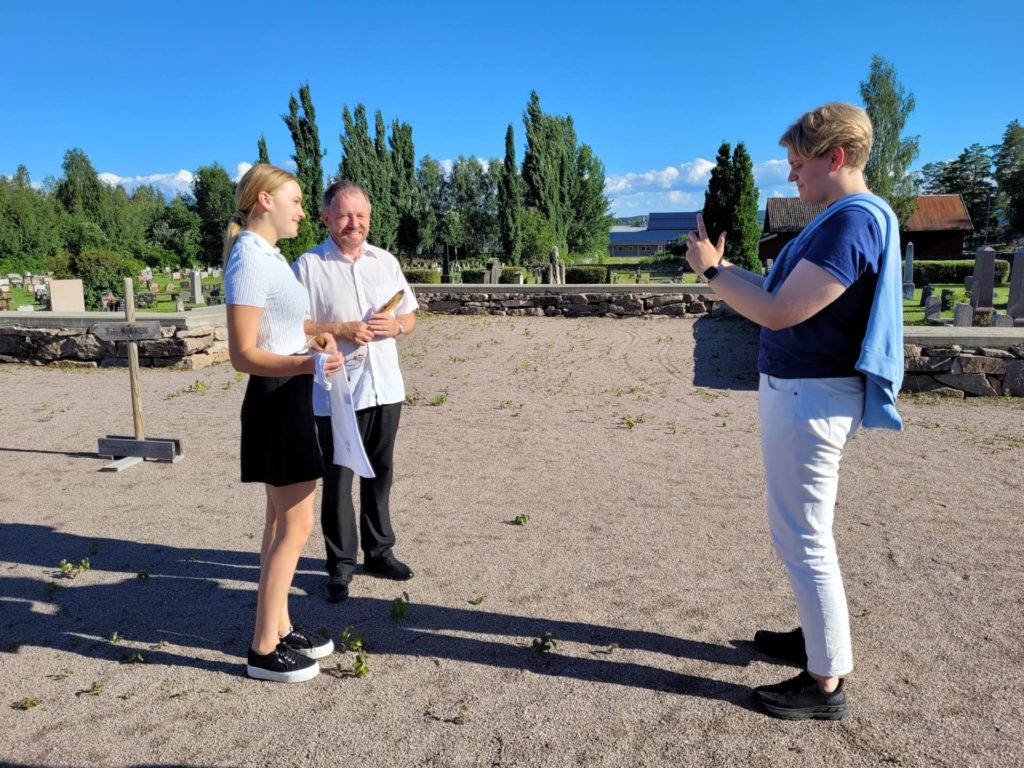 I SOSIALE MEDIER: Å møte masse ungdom på rundreise i juli kan være vrient, men sosiale medier er til god hjelp. Her filmer Frederik Feiler en video med Ingrid Vestby fra ungdomsrådet i Våler og sokneprest Einar Vannebo.