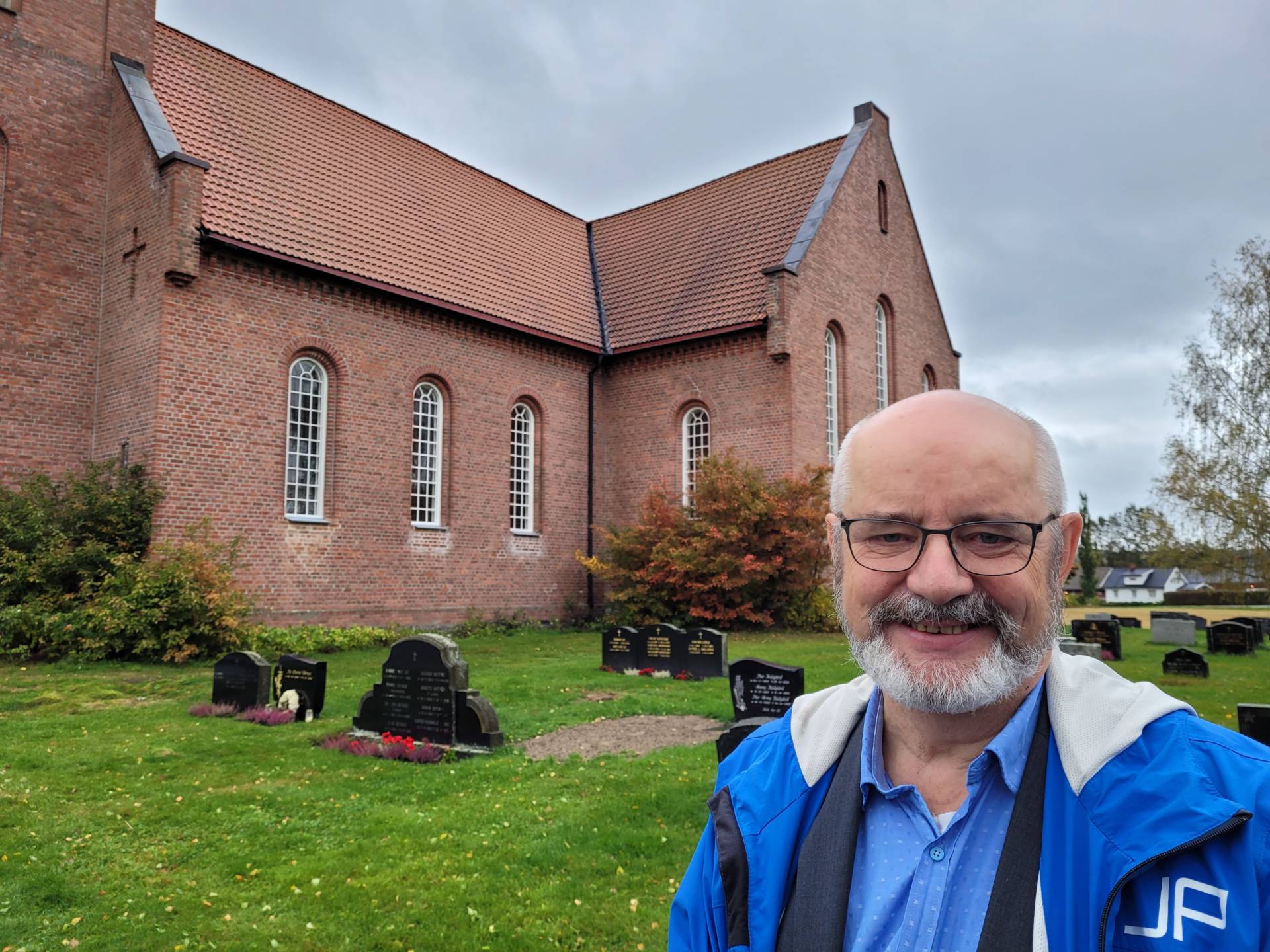 ER HALVVEIS: Vinduene på sørsiden av Hof kirke er nå byttet, og nordsiden tas neste år. Kirkeverge Tord Langmoen er fornøyd med resultatet.