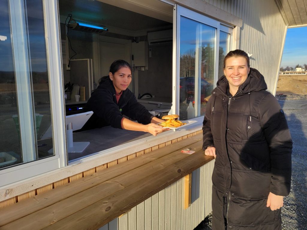 HOLDES ÅPEN: Kiosken «Færder'n» er flytet opp fra stranda, og holder åpent frem til jul i første omgang. Kenia Madsen serverer gjerne burgere og annet til Hanna Kroken og andre som stikker innom.