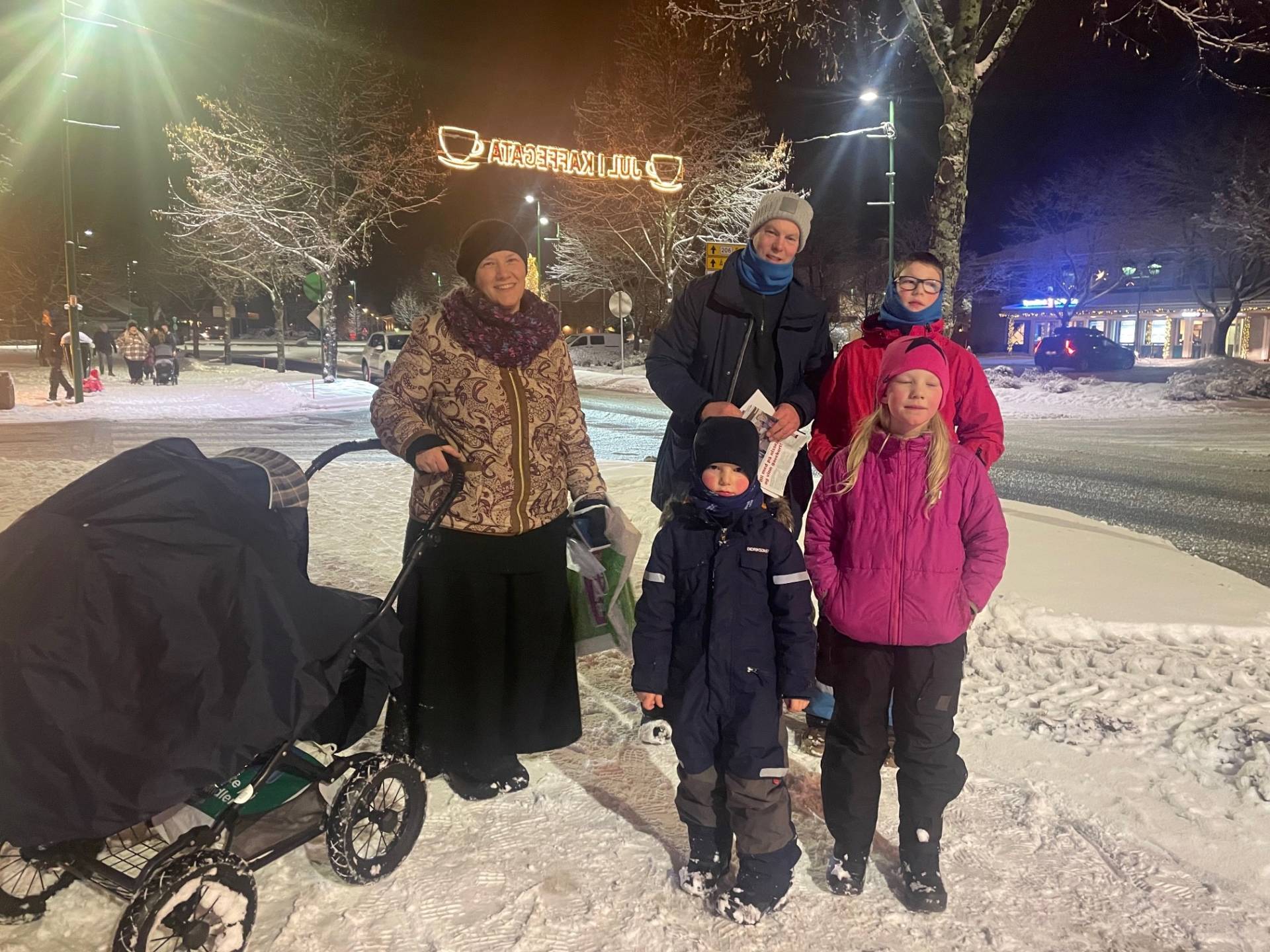 PÅ LETING ETTER NISSER: Sara Asprusten (7) (fra høyre), Fillip Asprusten (7), Kaleb Asprusten (4), Daniel Asprusten, Andree Asprusten og lille Anna Asprusten (10 måneder) i vogna koste seg alle sammen på julefestivalen på Flisa i helga. De gikk rundt i Kaffegata på leting etter nisser som var gjemt i butikkvinduene. Foto: Adele Dragsnes.