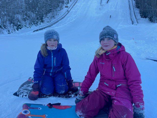 STORKOSER SEG I BAKKEN: Veslemøy Kravdal (10, til venstre) og Emilie Dalila Hjelmervik (10) har kjørt flere turer ned Gjerdrumsbakken og synes at det er veldig morsomt. Foto: Adele Dragsnes..