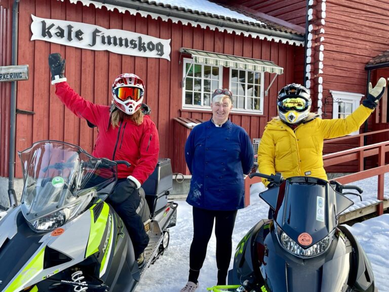 PRØVDE LEDEN: To Sprelske, Mari og Mats, fikk prøve snøscooterledene i Åsnes nylig. Her sammen med Thea Mannsee hos Kafé Finnskog. Foto: Visit Kongsvinger-regionen/To Sprelske.