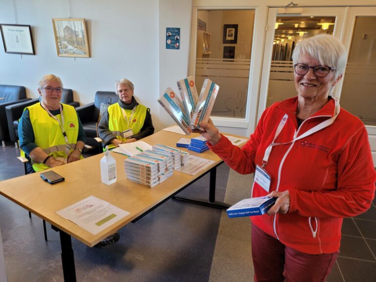 DELER UT: Åsnes Sanitetsforening sørger for at alle som trenger gratis hurtigtest i Åsnes får det. Anne Lise Kalfoss (foran) forteller at de har mer enn nok tester nå. Bak ser vi Dina Telle og Rigmor Solvang.
