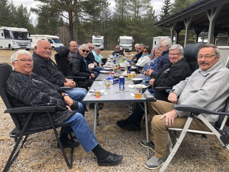 SOSIALT PÅ DUGNAD: Her sitter de frivillige og koser seg med mat etter dagen malingsøkt. Fra venstre, Gjerterud, Erik, Jorunn, Jan, Kjell, Bjørg, Inger, Laila, Kjell, Jan Ivar, Åsmund, Britt, Grethe, Willy, Iren og Magne. Foto: Adele Dragsnes