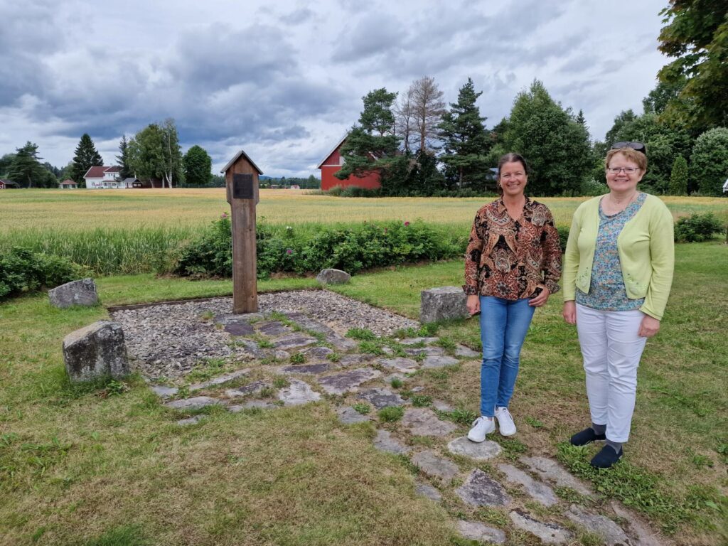 EN DEL AV JUBILEET: Søndagens pilegrimsgudsjeneste ved Mariakirken minnelund i Åsnesgrenda er en del av Olavsjubileet i Åsnes. Nina Aaser Damhaug (til venstre) og Rikka Østbye håper plenen blir full av gjester når prost Trine Færevåg holder gudstjenesten.