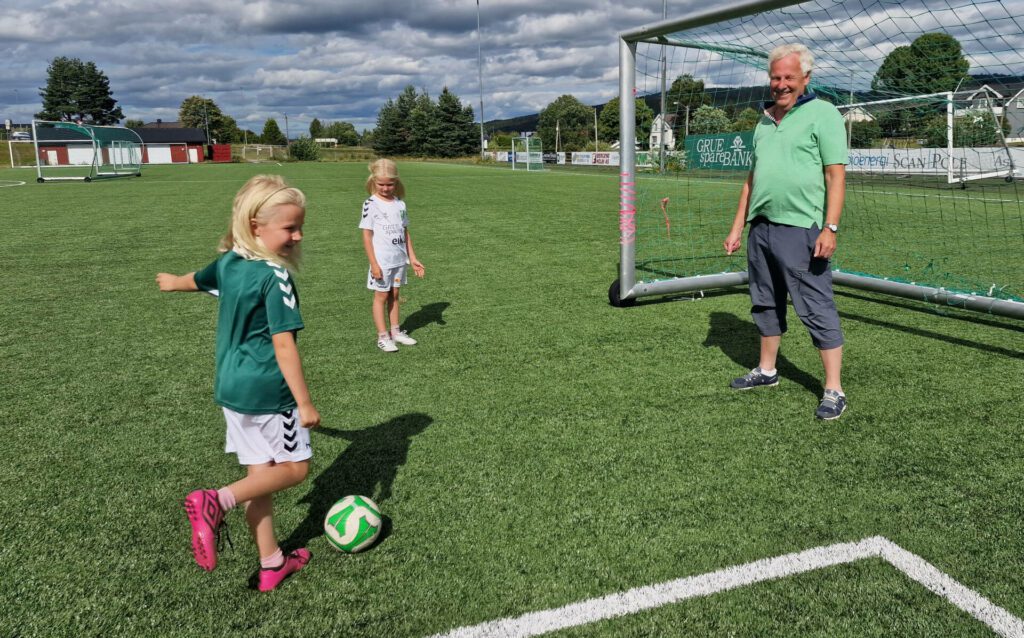 NÆRMER SEG: Vilde Hedblom (7) prøver seg gjerne på turneringsleder Roy Bråthen i mål, i påvente av Grueturneringen som starter snart. Bak står Ida Hedblom (5) og venter på tur.