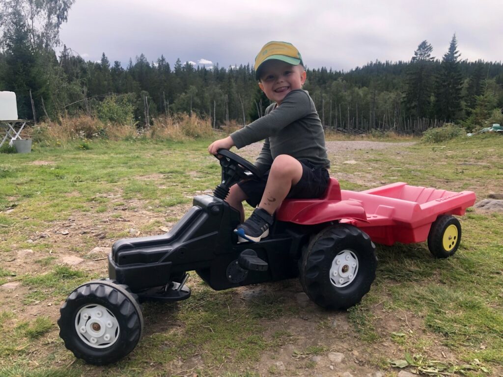 GØY MED TRAKTOR: Oscar Brynjulf Melby (3) koser seg på traktoren oppe på Braskerudsætra. Foto: Adele Dragsnes