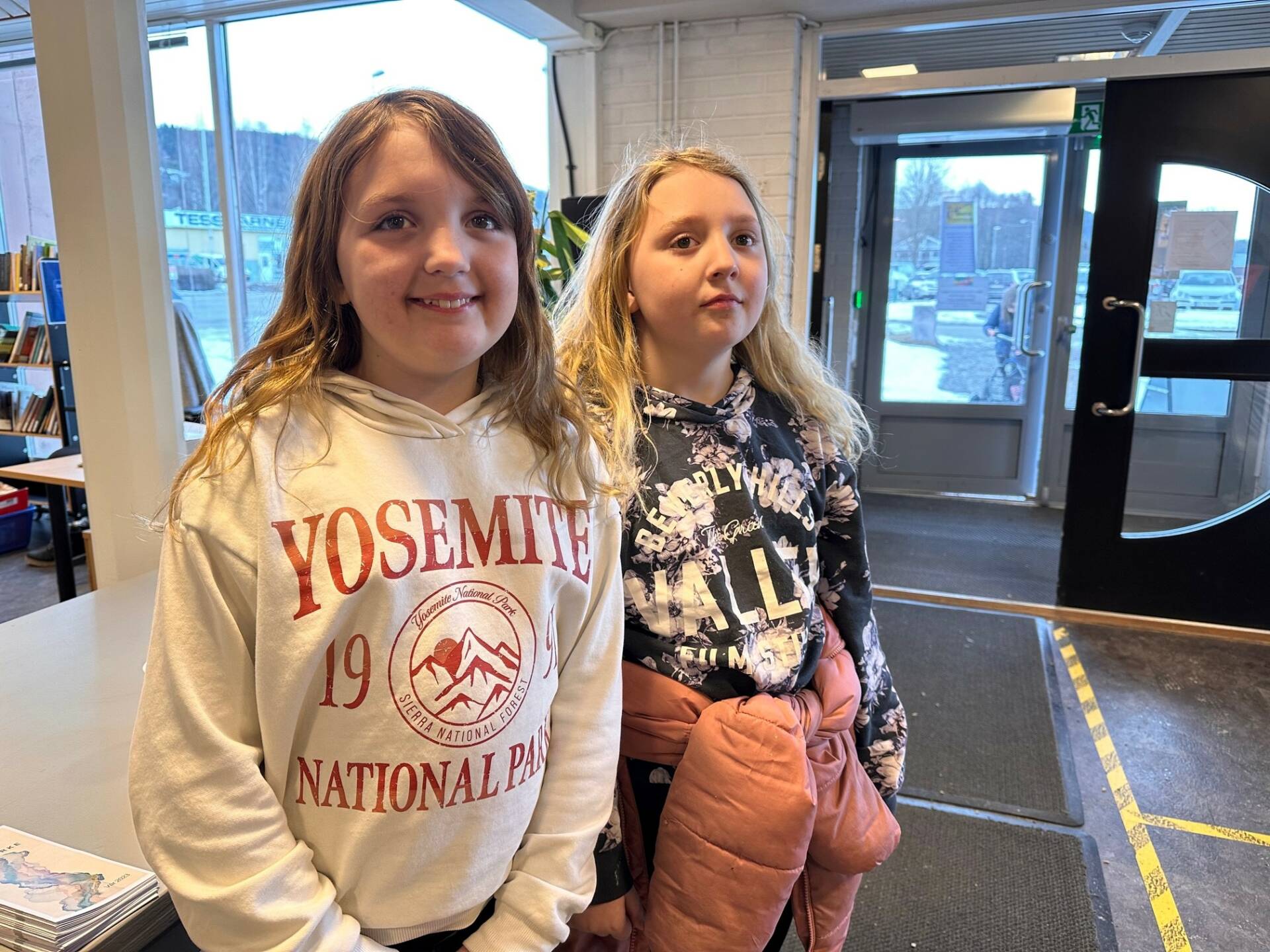 FORNØYDE: Emilie Sigvardsen (10) og Mathilde Sigvardsen (8) var to av mange som har gledet seg lenge til at bibiloteket endelig kunne åpne. Foto: Adele Dragsnes