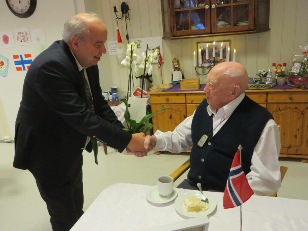 ORKIDE TIL 100-ÅRINGEN: Varaordfører Per Roar Bredvold hilste fra kommunen og overrakte blomster til jubilanten. Foto: hans-Didrik Bakke.